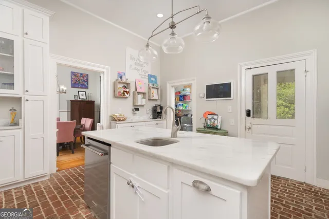 a view of kitchen island a sink and a refrigerator