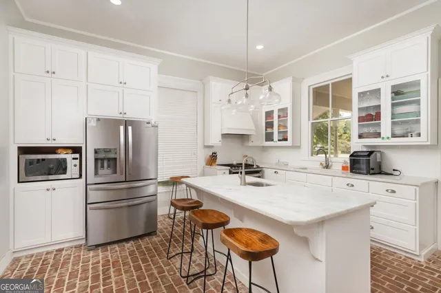 a kitchen with granite countertop a stove a refrigerator and a sink