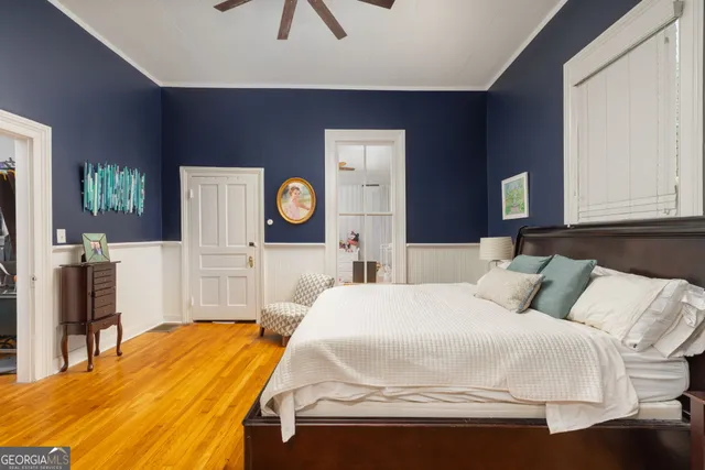 a bedroom with a bed and a flat tv screen on dresser