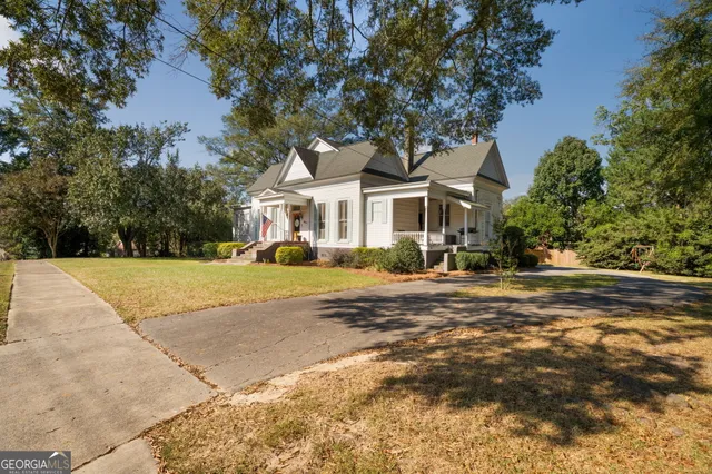 a front view of a house with a yard and trees