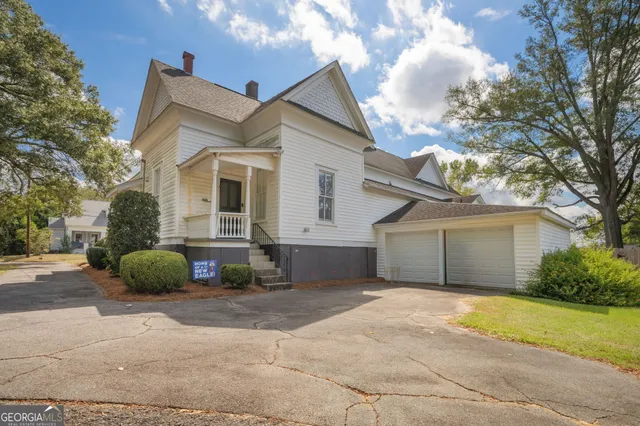 a view of a house with a yard and large tree