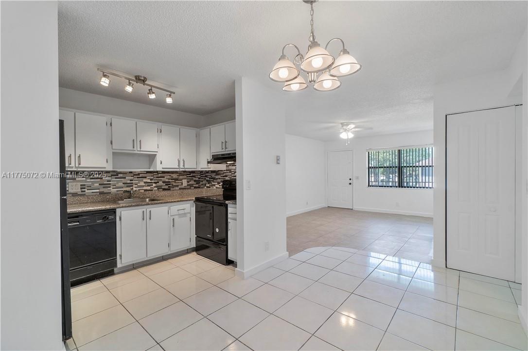 3266 Northwest 104th Avenue, Unit 3266 Coral Springs, FL 33065 - Photo 7 of 15 a kitchen with a stove a refrigerator and chandelier