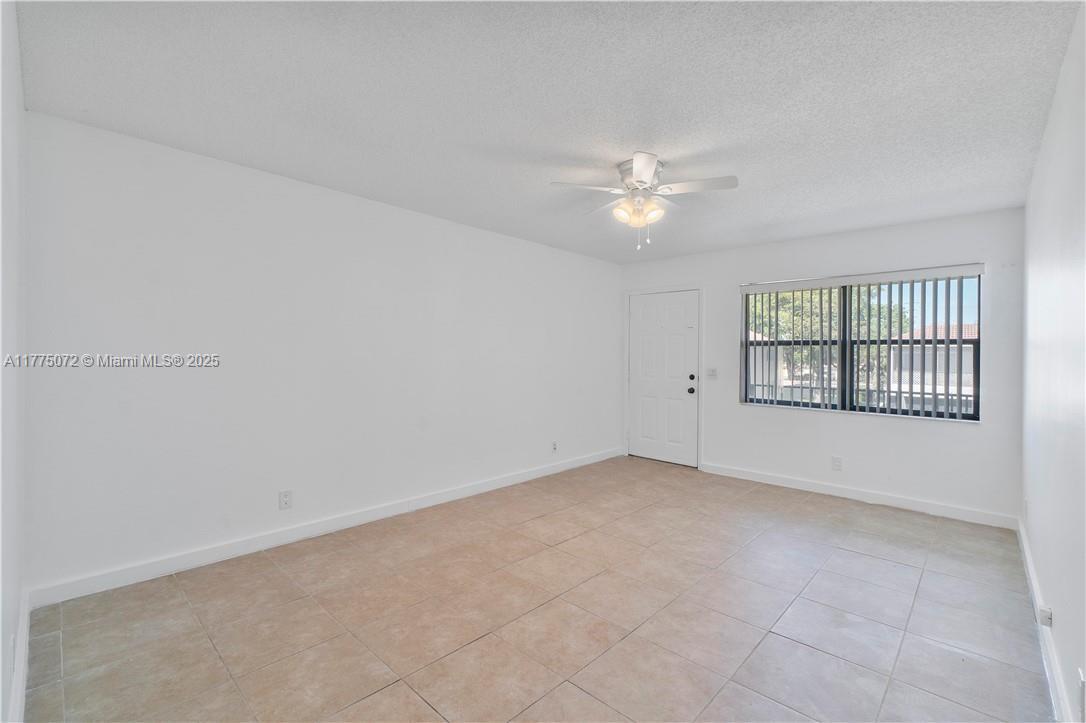 3266 Northwest 104th Avenue, Unit 3266 Coral Springs, FL 33065 - Photo 9 of 15 wooden floor in an empty room with a window