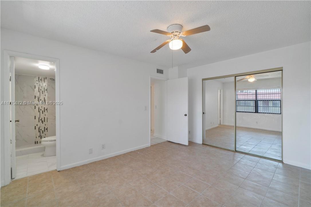 3266 Northwest 104th Avenue, Unit 3266 Coral Springs, FL 33065 - Photo 10 of 15 an empty room with fan and mirror