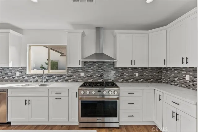 a kitchen with white cabinets and a stove