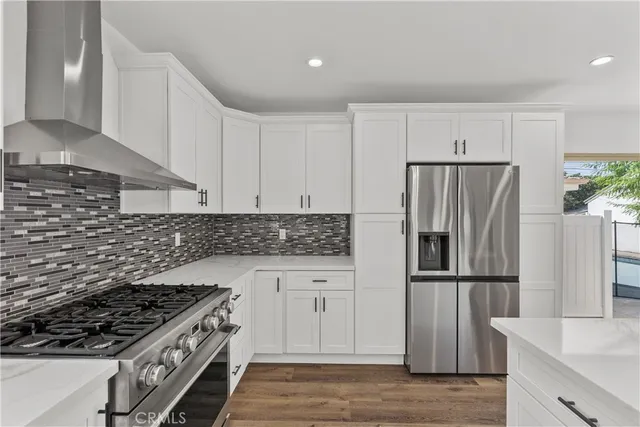 a kitchen with granite countertop a refrigerator and a stove top oven