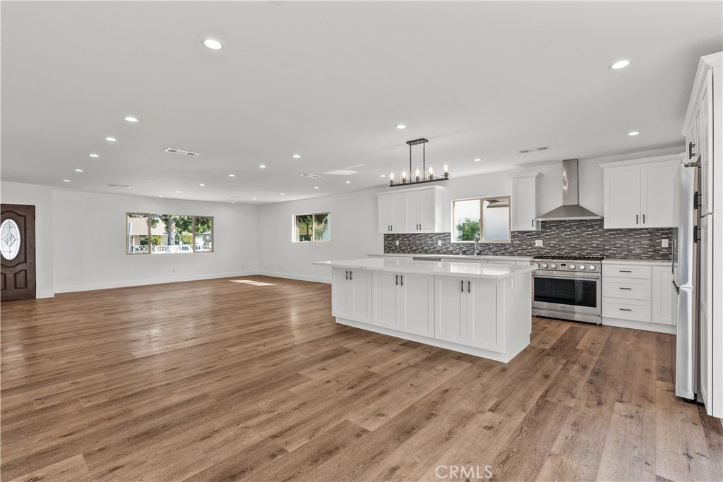 7419 Gloria Avenue Van Nuys, CA 91406 - Photo 16 of 51 a large kitchen with stainless steel appliances granite countertop a stove a sink dishwasher and a oven with white cabinets