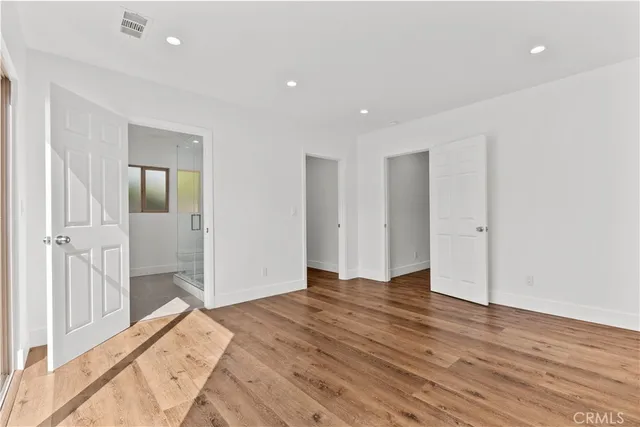 a view of a big room with wooden floor and windows
