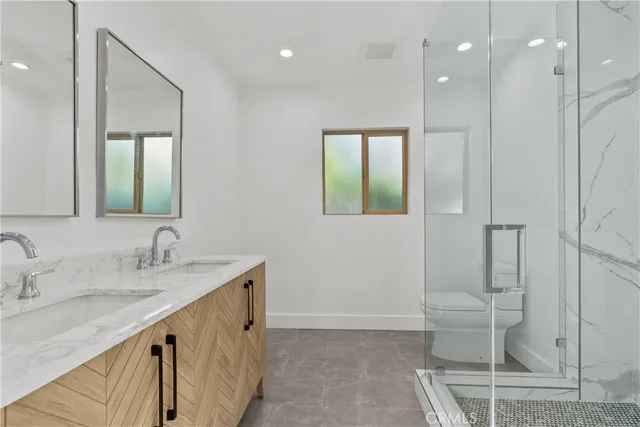 a bathroom with a double vanity sink mirror and toilet