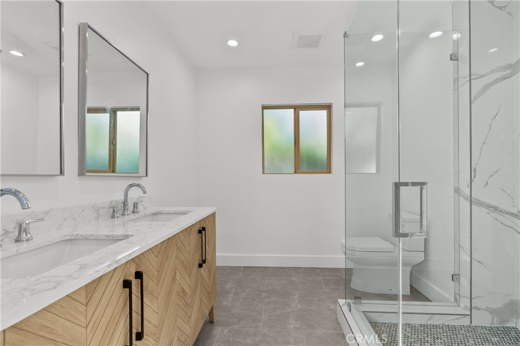 7419 Gloria Avenue Van Nuys, CA 91406 - Photo 26 of 51 a bathroom with a double vanity sink mirror and toilet