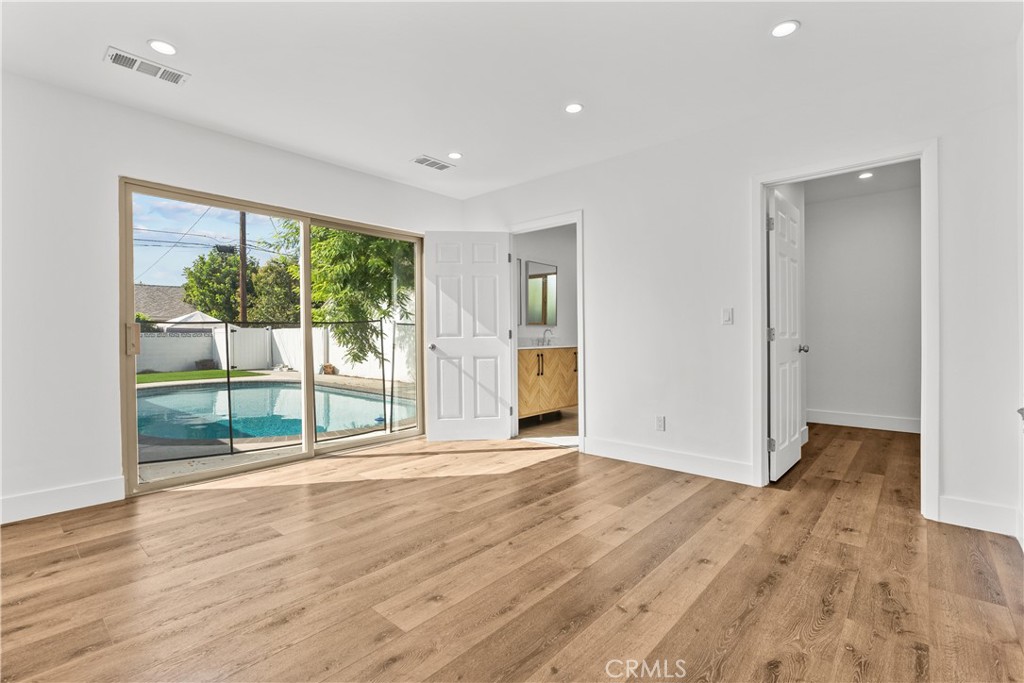 7419 Gloria Avenue Van Nuys, CA 91406 - Photo 29 of 51 a view of an empty room with wooden floor and a window