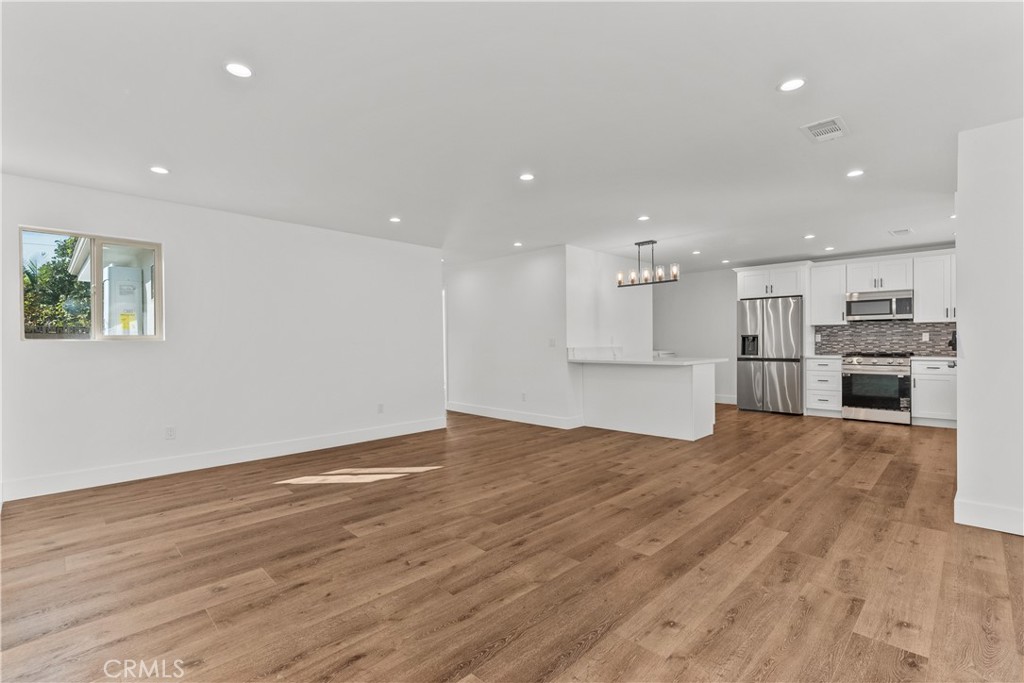 7419 Gloria Avenue Van Nuys, CA 91406 - Photo 34 of 51 an empty room with wooden floor and windows