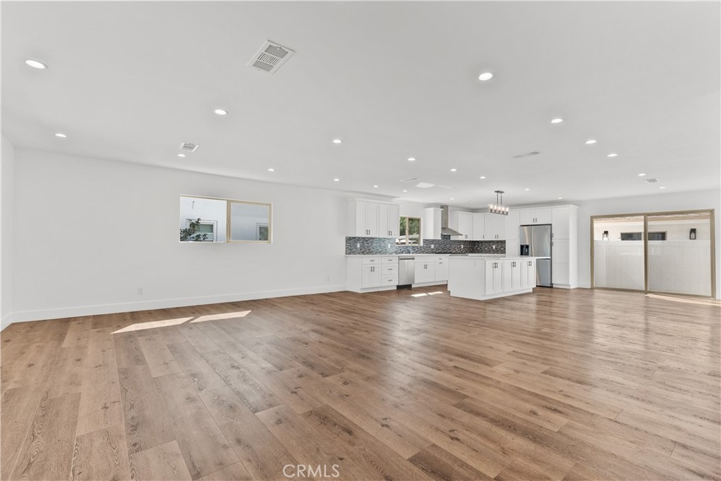 7419 Gloria Avenue Van Nuys, CA 91406 - Photo 6 of 51 a view of an empty room with wooden floor and a window