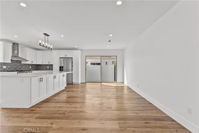 a large white kitchen with granite countertop a stove top oven and cabinets