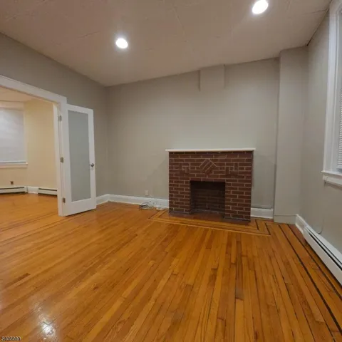 a view of empty room with wooden floor and fireplace