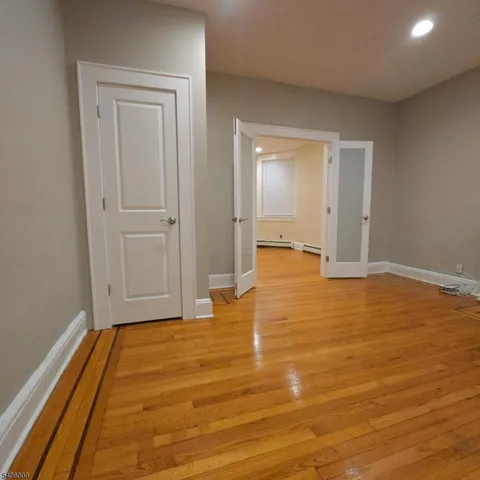 a view of empty room with wooden floor