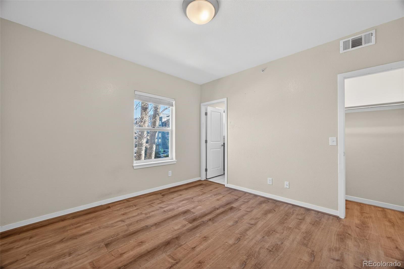 2389 South High Street, Unit 4 Denver, CO 80210 - Photo 17 of 32 a view of an empty room with wooden floor and a window