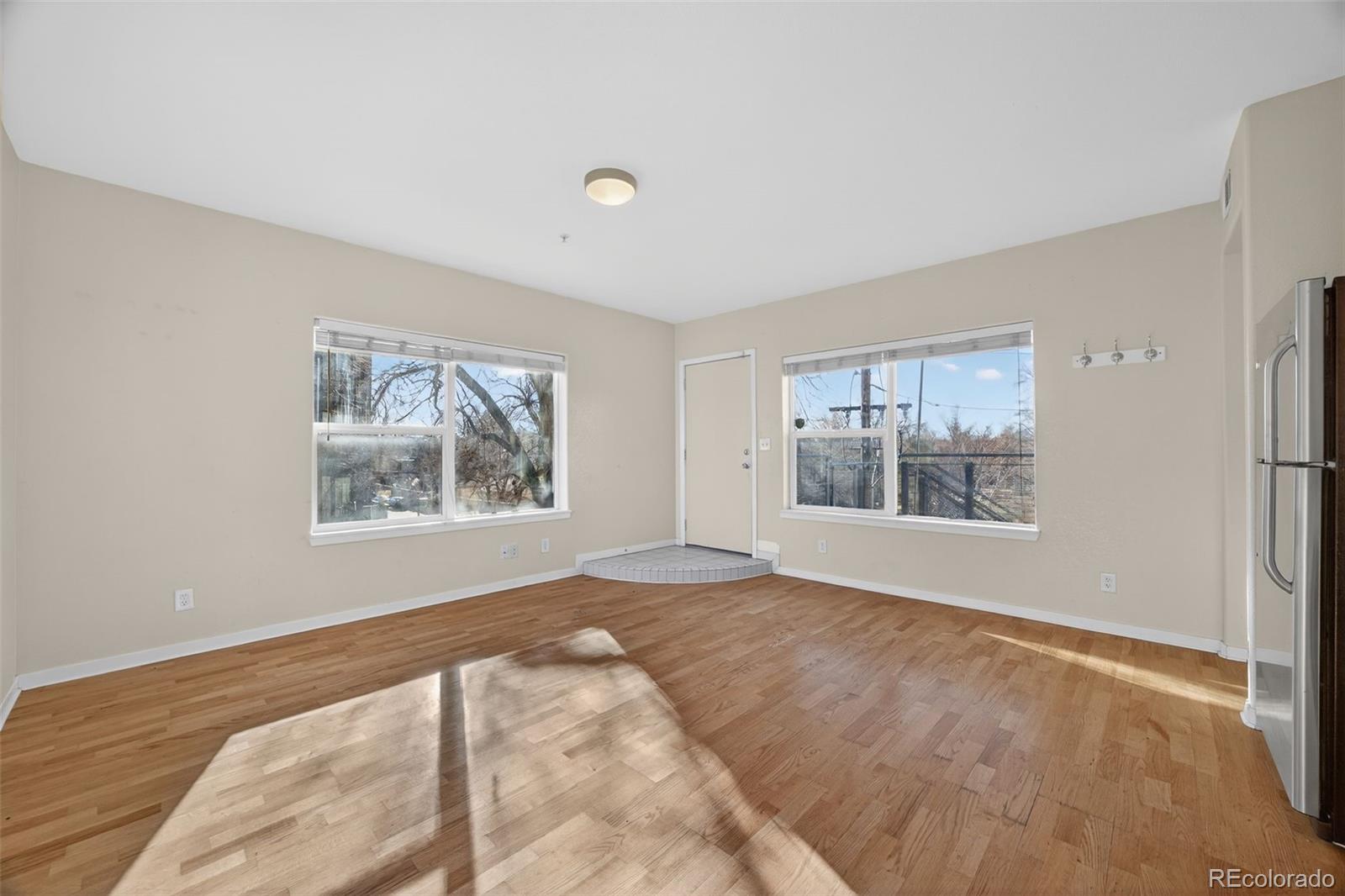 2389 South High Street, Unit 4 Denver, CO 80210 - Photo 7 of 32 a view of an empty room with a window and a kitchen