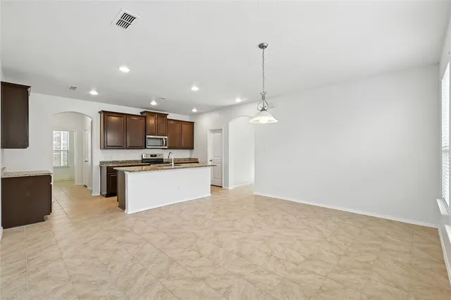 a view of kitchen with kitchen island a sink stainless steel appliances and white cabinets