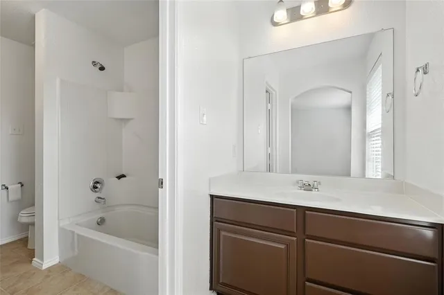 a bathroom with a tub sink and mirror