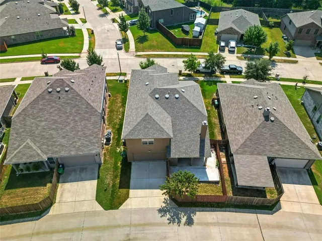 an aerial view of multiple houses with a yard