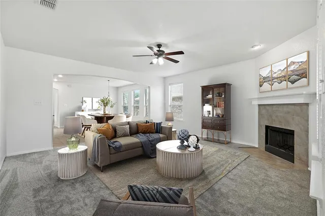 a living room with furniture a fireplace and a chandelier