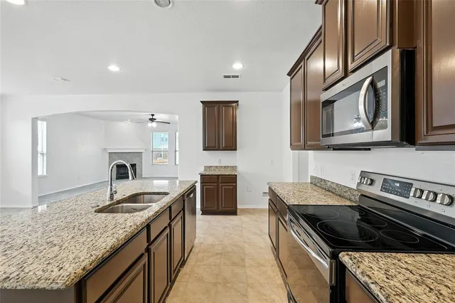 a kitchen with stainless steel appliances granite countertop a sink stove and refrigerator