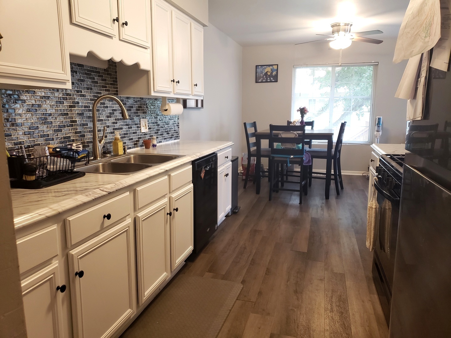 524 Sandhurst Lane South Elgin, IL 60177 - Photo 6 of 32 a kitchen with stainless steel appliances granite countertop wooden floors a stove top oven a dining table and chairs with wooden floor