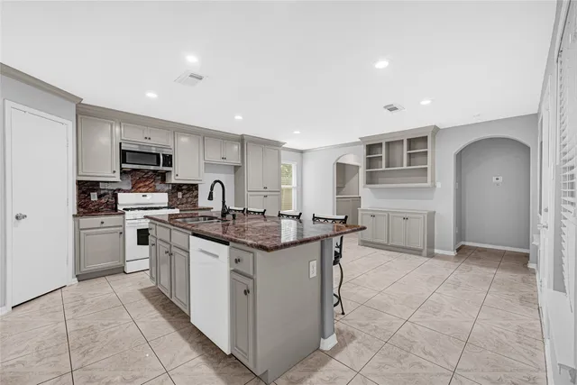 a kitchen with stainless steel appliances granite countertop a stove top oven a sink a counter top space and cabinets