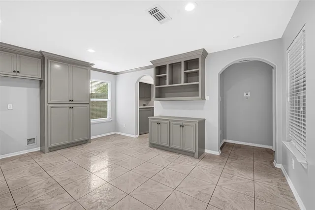a kitchen with white cabinets and appliances
