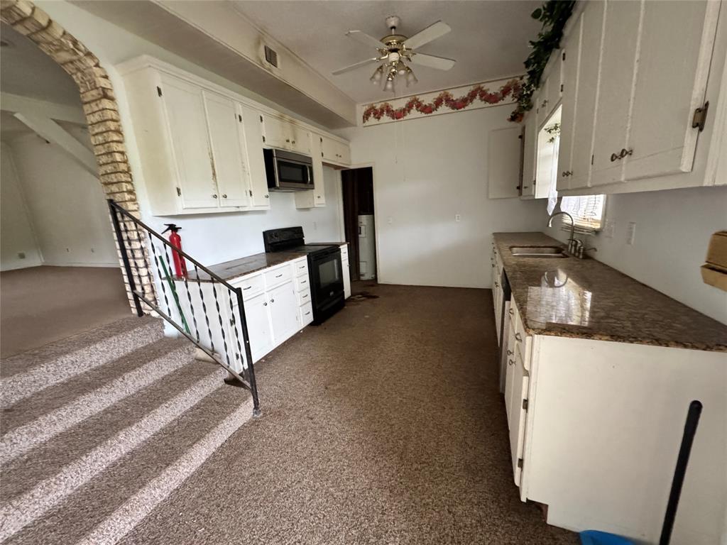 3909 Smothers Road Caney City, TX 75148 - Photo 17 of 35 a kitchen with furniture a stove top oven and cabinets