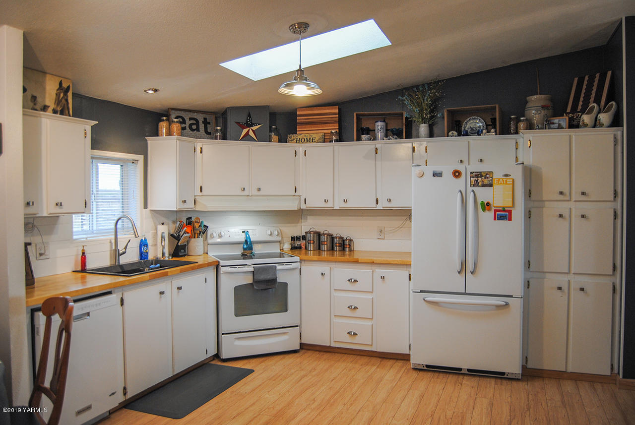 4971 Beam Road Granger, WA 98932 - Photo 4 of 24 a kitchen with white cabinets and white appliances