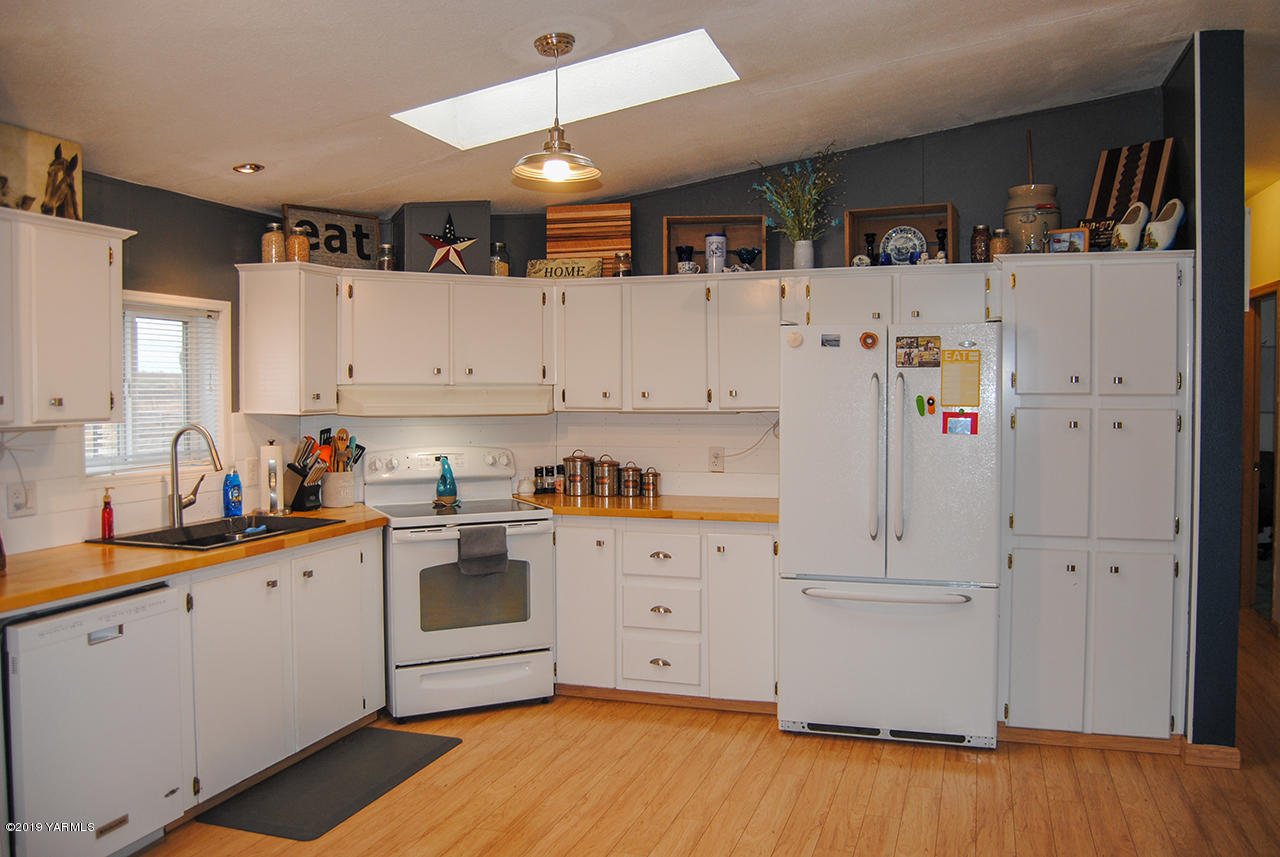 4971 Beam Road Granger, WA 98932 - Photo 6 of 24 a kitchen with cabinets a refrigerator and a sink