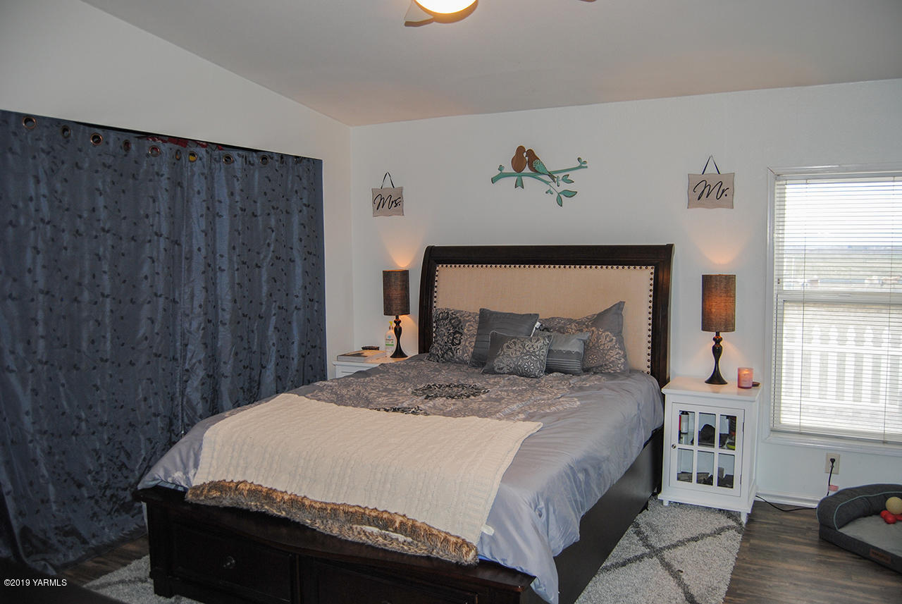 4971 Beam Road Granger, WA 98932 - Photo 8 of 24 a bed sitting in a bedroom next to a window