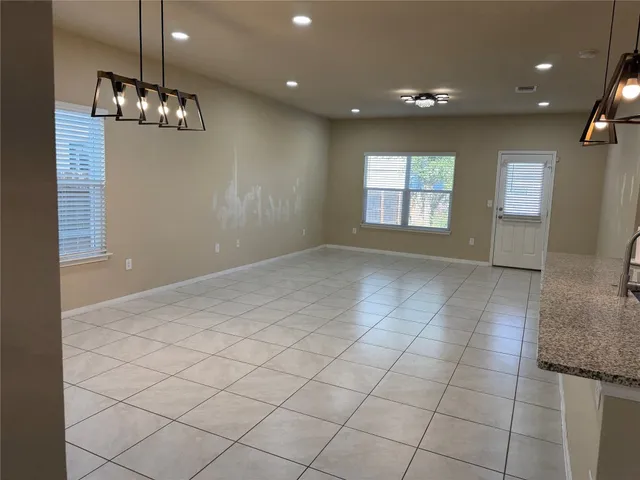 a kitchen with stainless steel appliances kitchen island granite countertop a refrigerator and a sink
