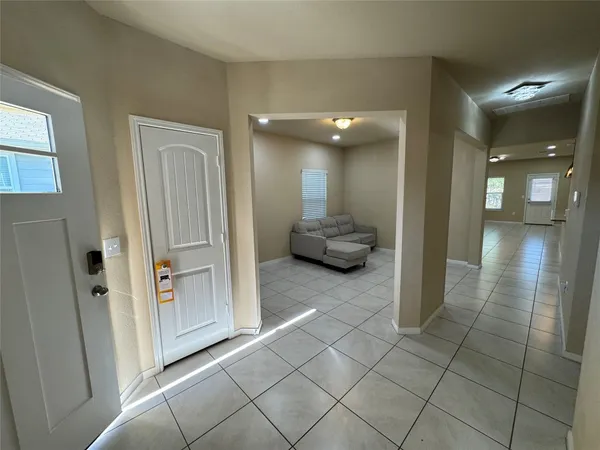 a view of a hallway with bathroom and mirror