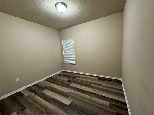 an empty room with wooden floor and closet