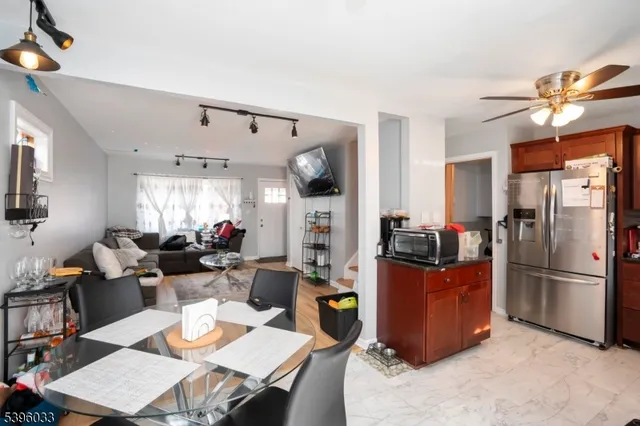 a living room with stainless steel appliances furniture a rug and a view of kitchen