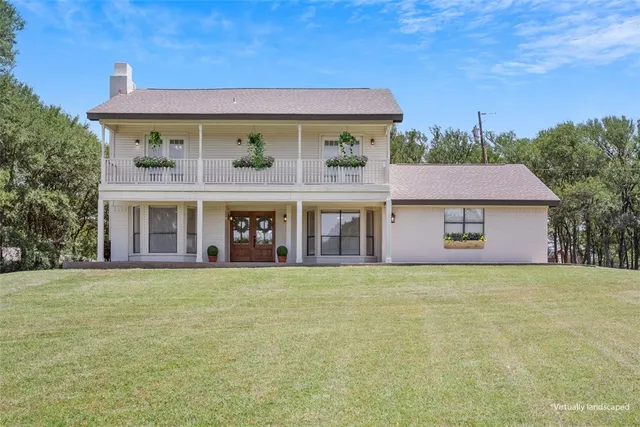 a front view of a house with glass windows and a yard
