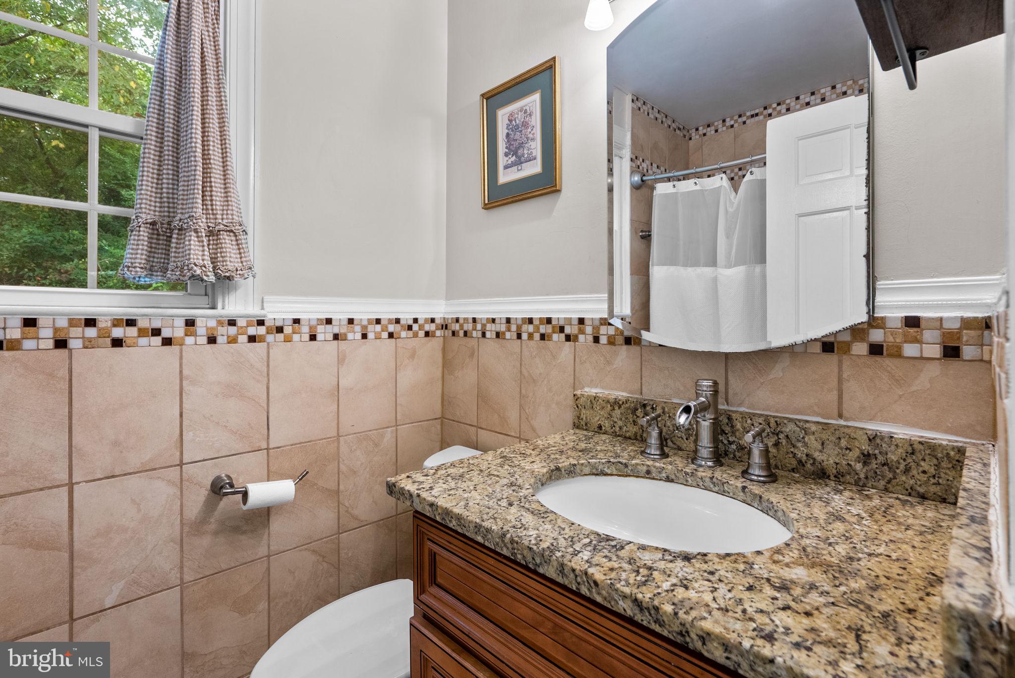 3403 Varnum Street Brentwood, MD 20722 - Photo 14 of 20 a bathroom with a granite countertop sink a mirror and a shower
