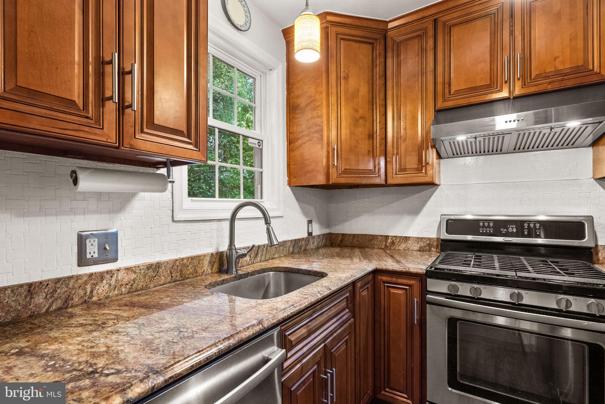3403 Varnum Street Brentwood, MD 20722 - Photo 9 of 20 a kitchen with granite countertop wood cabinets stainless steel appliances and a sink