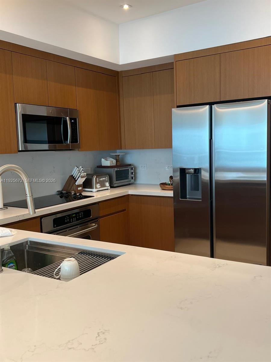 31 Southeast 5th Street, Unit 3921 Miami, FL 33131 - Photo 11 of 34 a kitchen with stainless steel appliances a sink a stove and a refrigerator