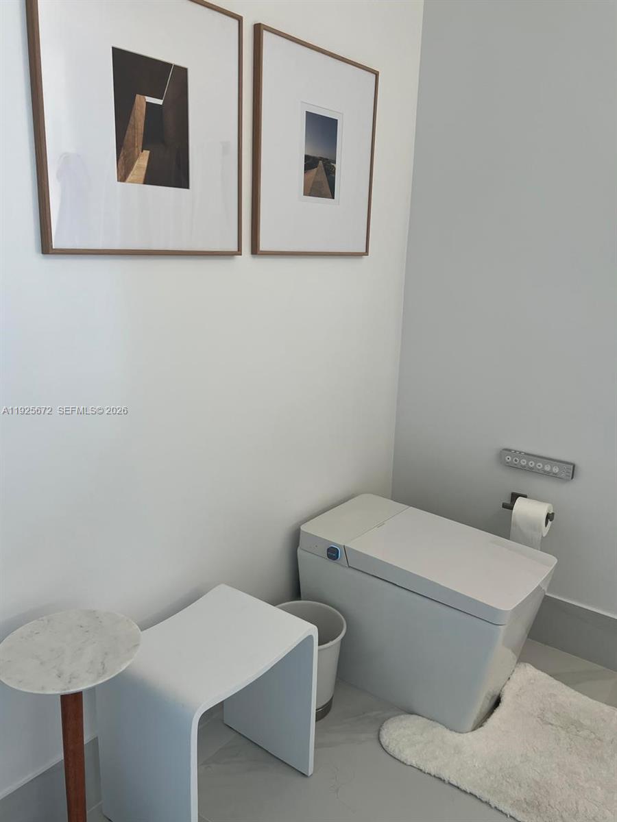 31 Southeast 5th Street, Unit 3921 Miami, FL 33131 - Photo 15 of 34 a white toilet sitting next to a bathroom sink