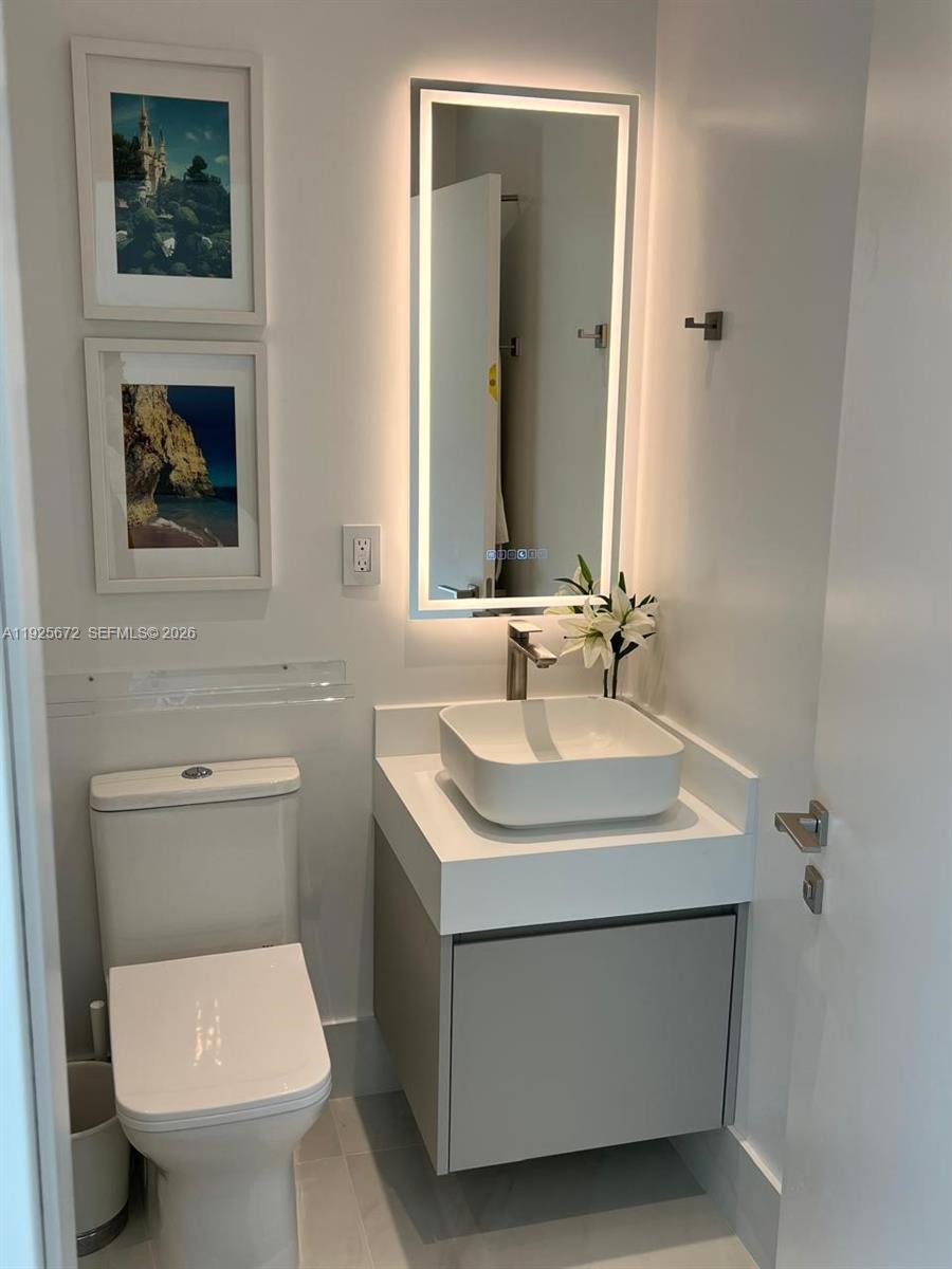 31 Southeast 5th Street, Unit 3921 Miami, FL 33131 - Photo 17 of 34 a bathroom with a toilet sink and mirror