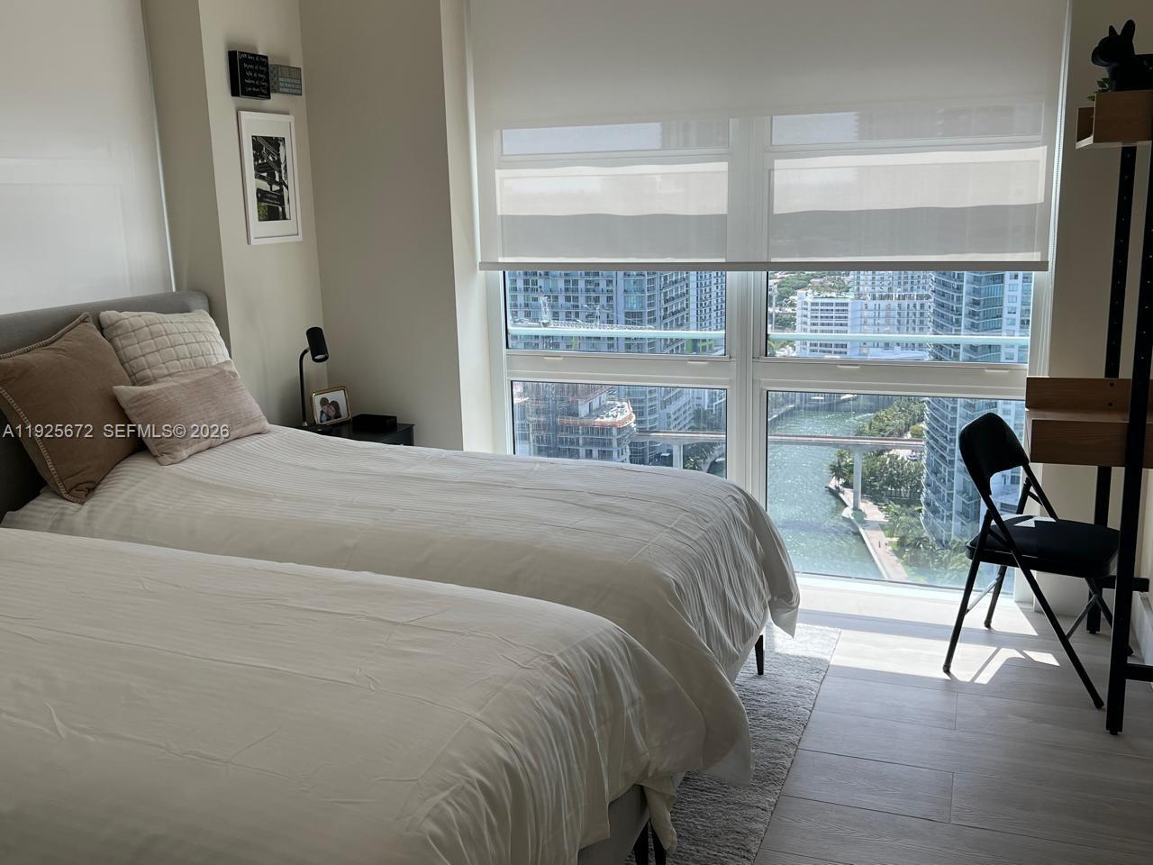 31 Southeast 5th Street, Unit 3921 Miami, FL 33131 - Photo 18 of 34 a bedroom with a bed a chair and a large window with the balcony view