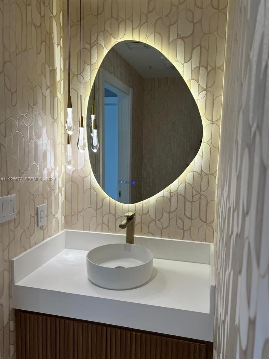 31 Southeast 5th Street, Unit 3921 Miami, FL 33131 - Photo 24 of 34 a bathroom with a sink and a mirror