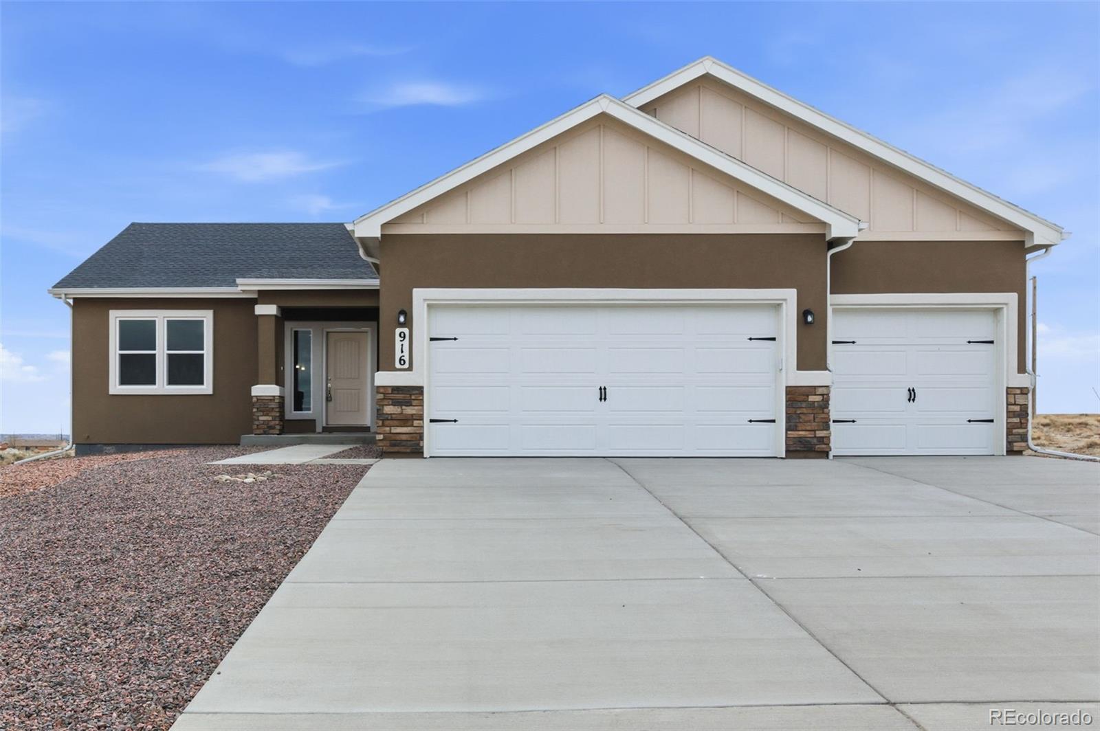 24615 Big Springs Road Pueblo West, CO 81007 - Photo 1 of 24 a front view of a house with a yard and garage