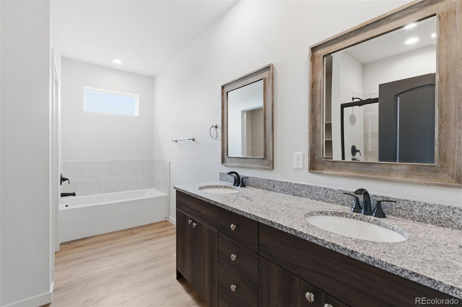 24615 Big Springs Road Pueblo West, CO 81007 - Photo 21 of 24 a bathroom with a granite countertop double vanity sink and mirror
