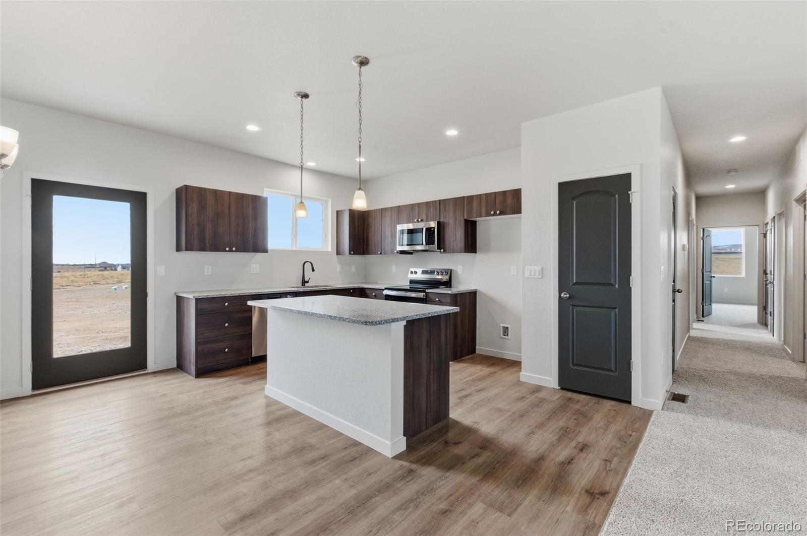 24615 Big Springs Road Pueblo West, CO 81007 - Photo 6 of 24 a kitchen with stainless steel appliances granite countertop a refrigerator a sink a stove and oven