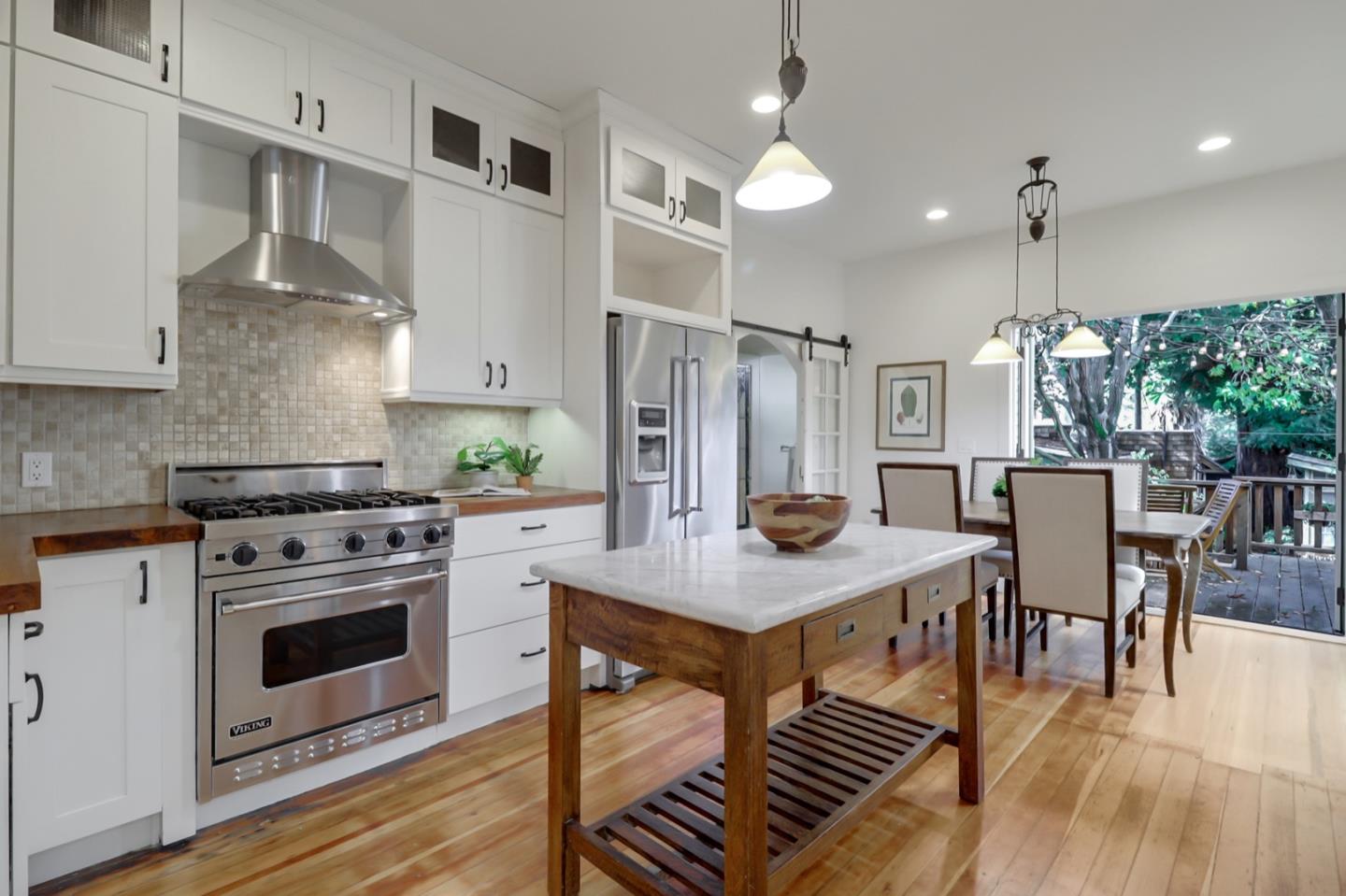 2614 Etna Street Berkeley, CA 94704 - Photo 17 of 59 a kitchen with stainless steel appliances a stove a refrigerator a kitchen island a table and chairs